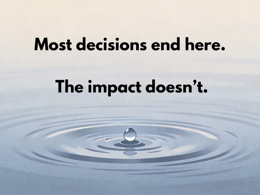 A single water droplet touching a calm surface, creating gentle concentric ripples that spread outward.